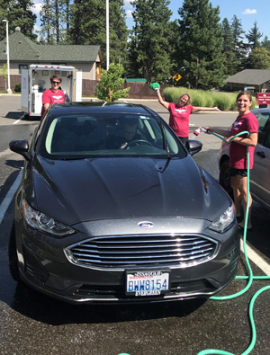People cleaning a car at the Customer Appreciation Car wash